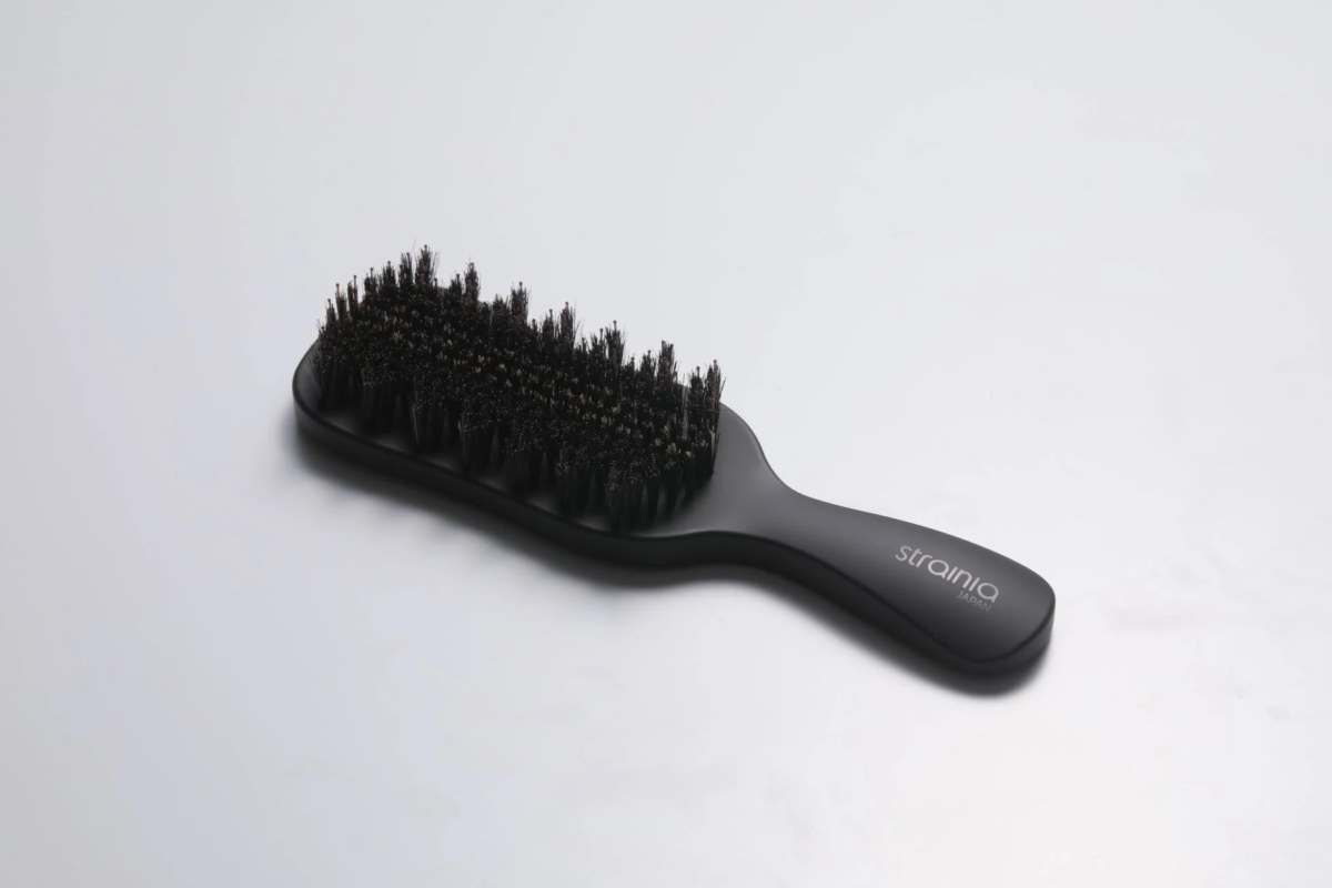 白い背景に置かれた黒いヘアブラシ