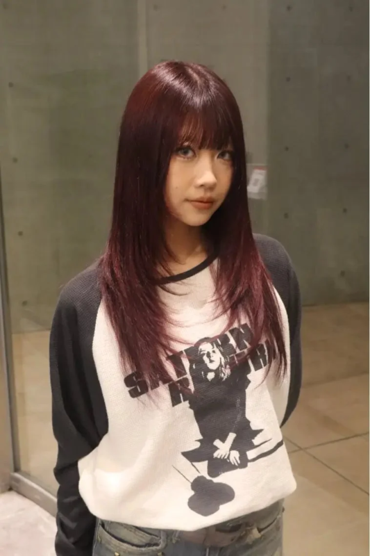 ボルドー系のロングレイヤーヘアの女性