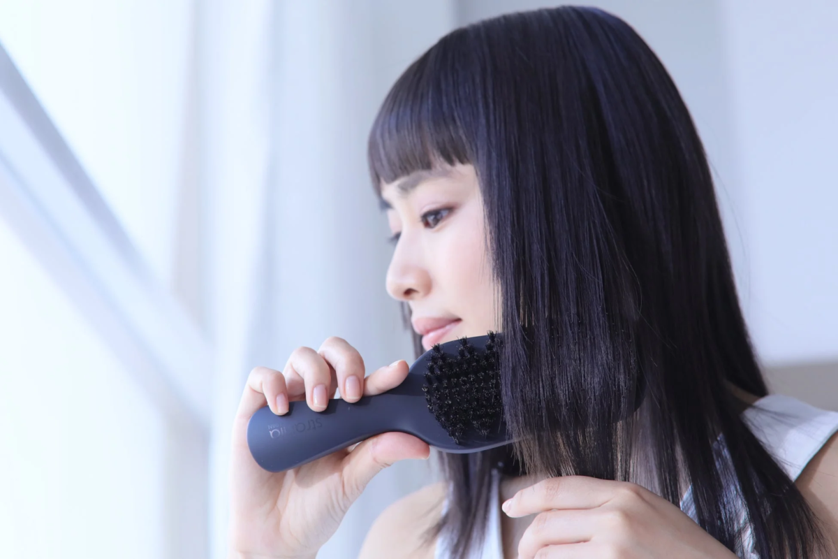 女性がヘアブラシで髪をとかす様子