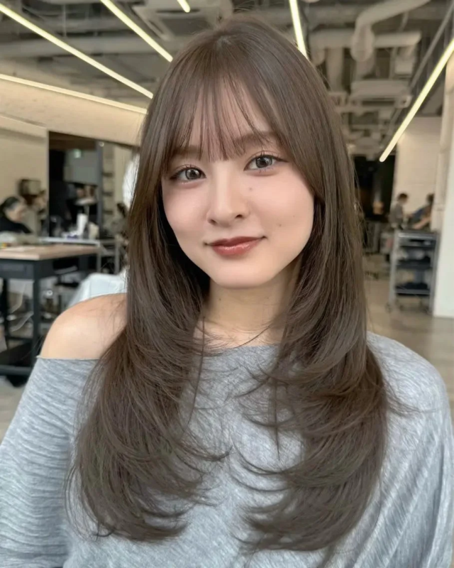 茶色のレイヤーカットのロングヘアの女性