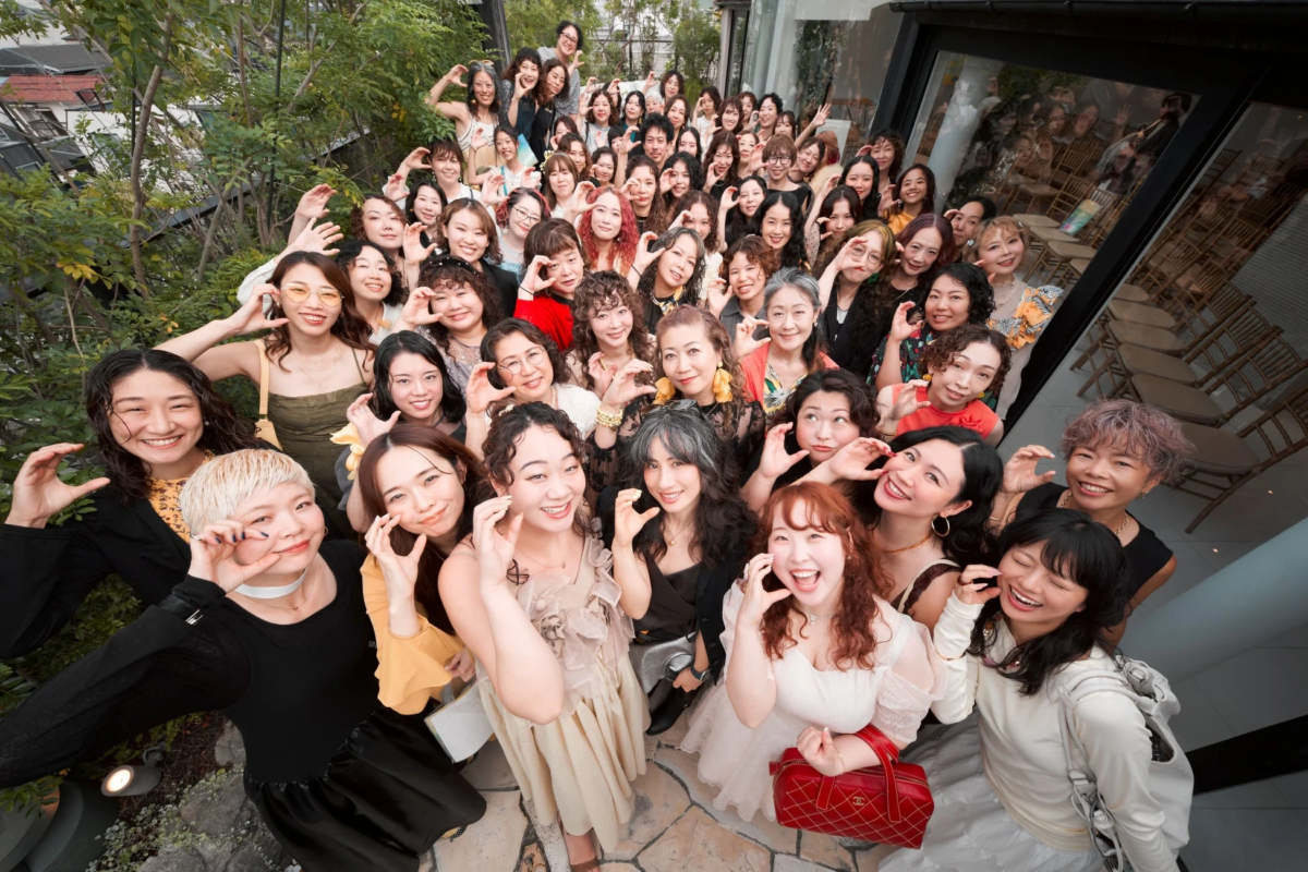 多くの女性が屋外で笑顔でポーズをとっている集合写真