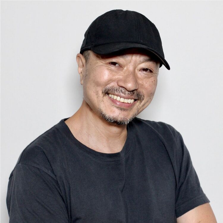 黒いキャップをかぶって笑顔を見せる、UNMIXビューティークリエイターの吉川康雄