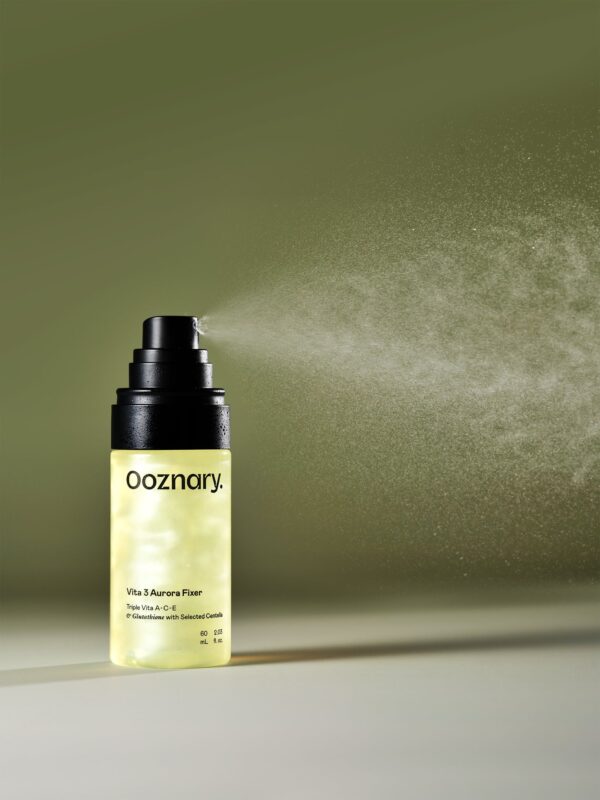 A bottle of Vita3 Aurora Mist spraying mist