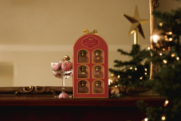 The red Petit Eau de Parfum Set Wonders with six bottles, placed beside a Christmas tree