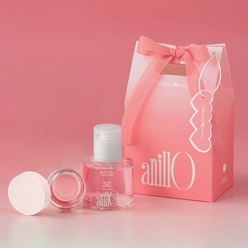 The Hair & Lip Care Set, with a pink gift bag, a hair essence and a jar of balm lined up