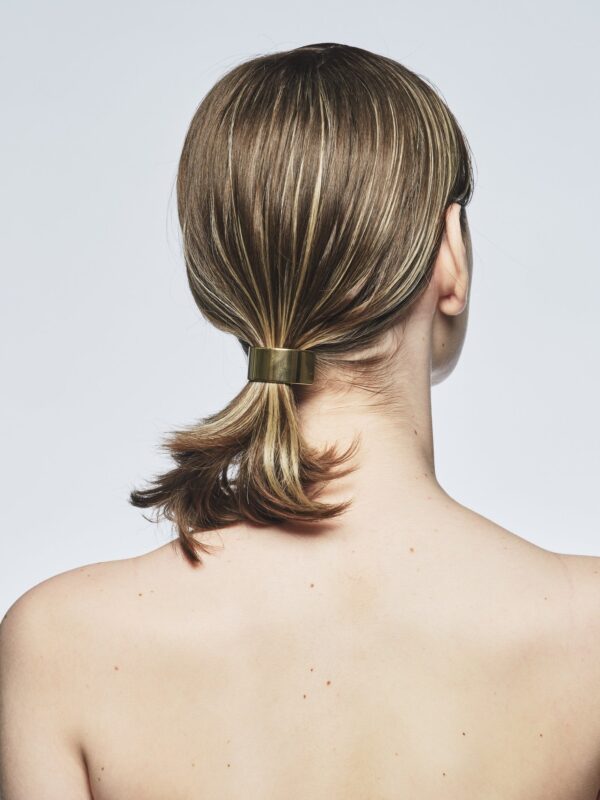 シートエクステを使い、ゴールドのヘアアクセサリーで髪をまとめたスタイル