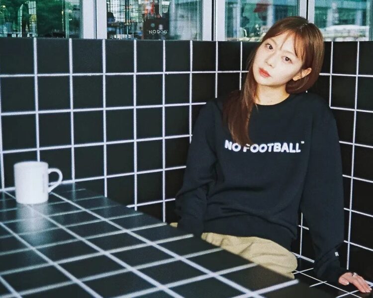 NO FOOTBALLロゴの黒いスウェットを着たモデル