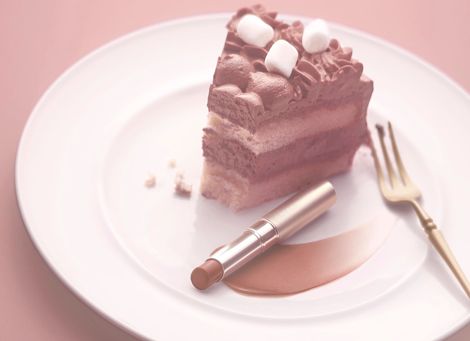 チョコレートケーキの皿に置かれた、オペラ シアーマットリップスティックと、塗り広げたブラウンの色