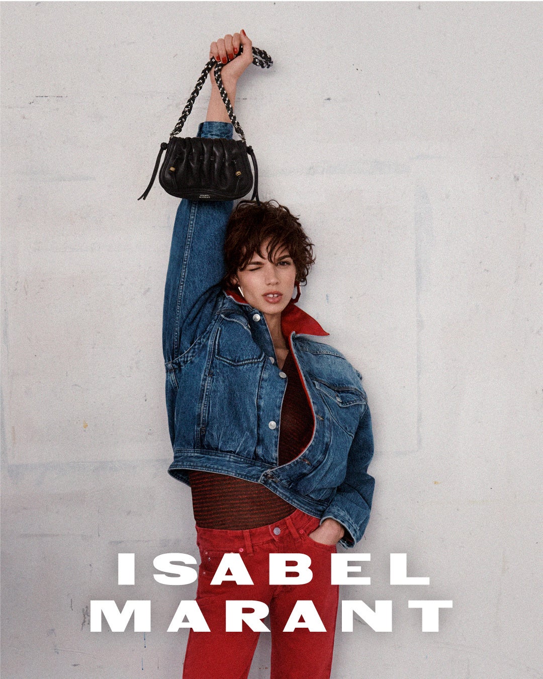 デニムジャケット姿のモデルがバッグを掲げる、ISABEL MARANTのビジュアル