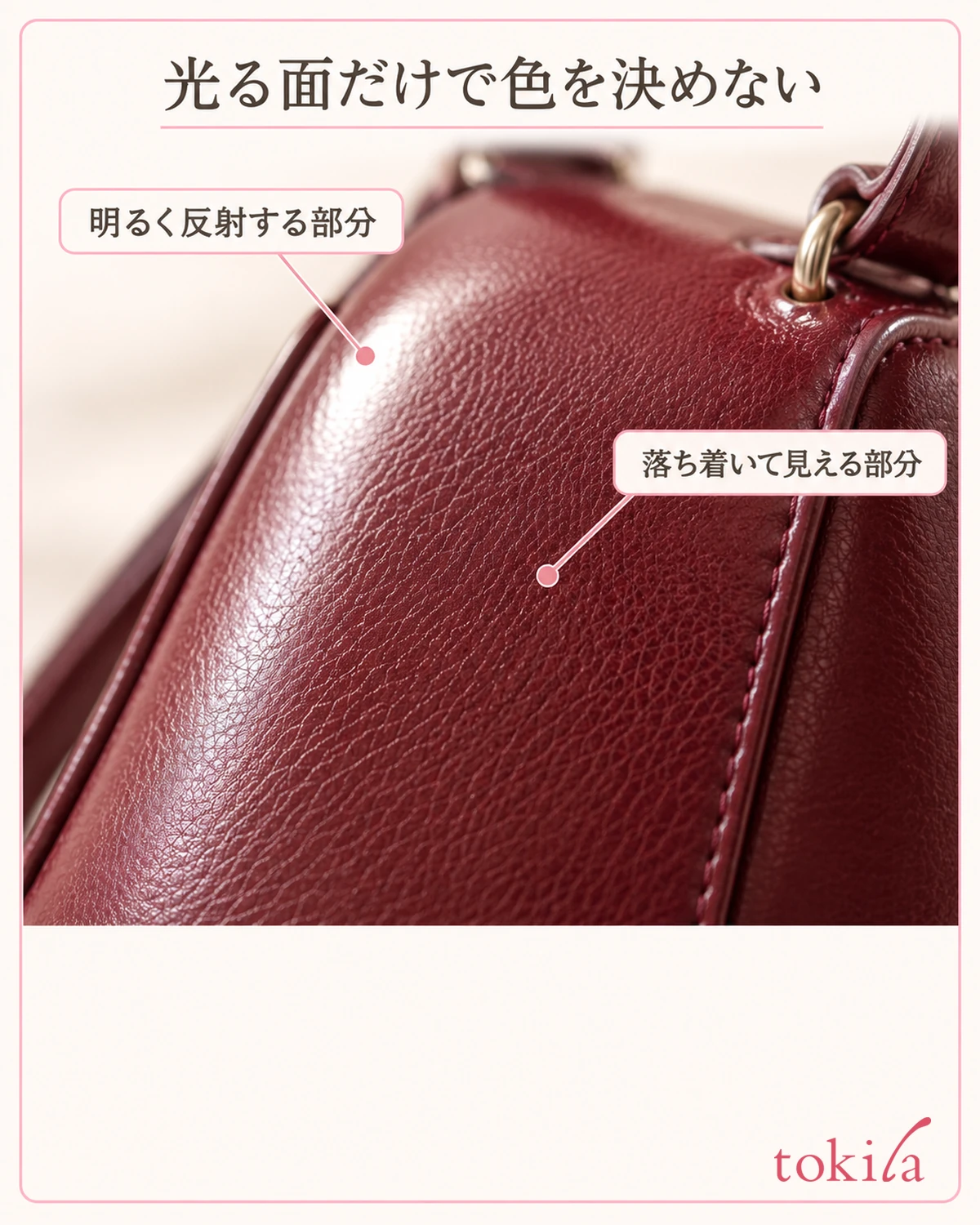 A part of a burgundy surface showing a bright reflection and a grained texture