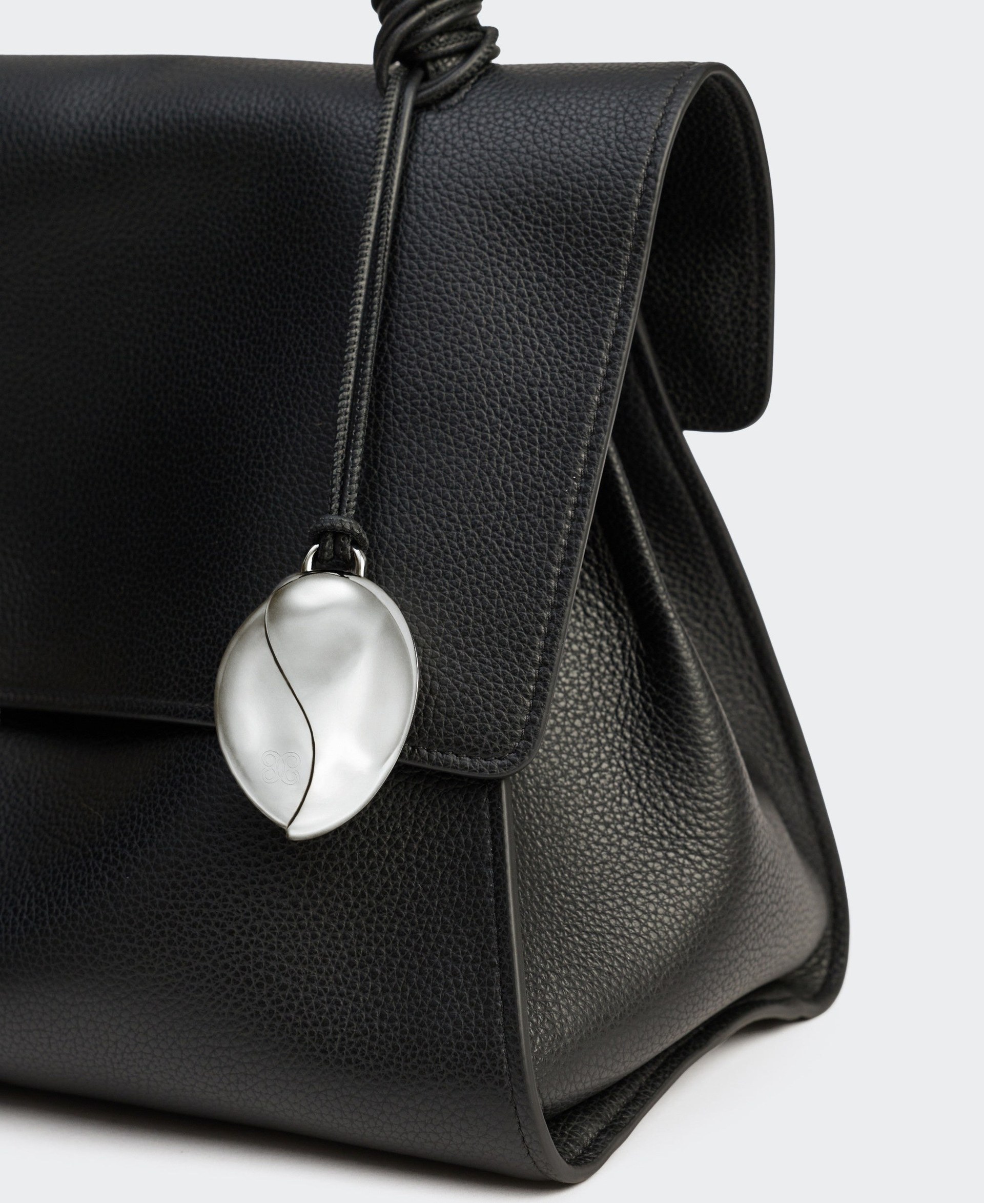 Basalt Mirror Charm attached to a bag