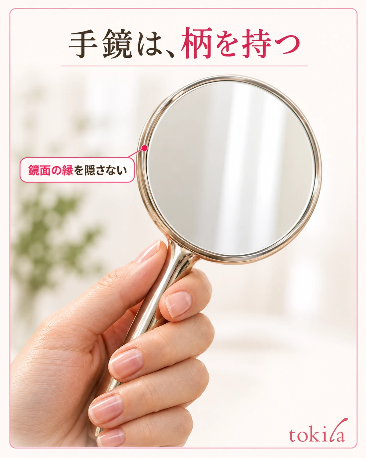 鏡面の丸い縁と、柄を支える指の位置