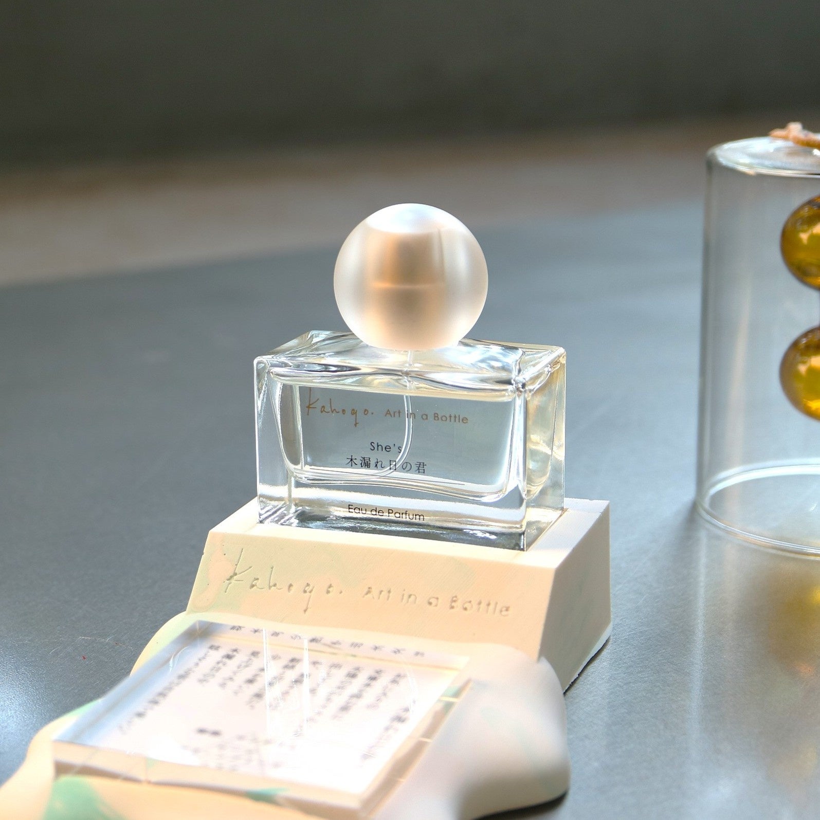 箱の上に置かれたkahogo. Art in a bottle『木漏れ日の君』のボトル